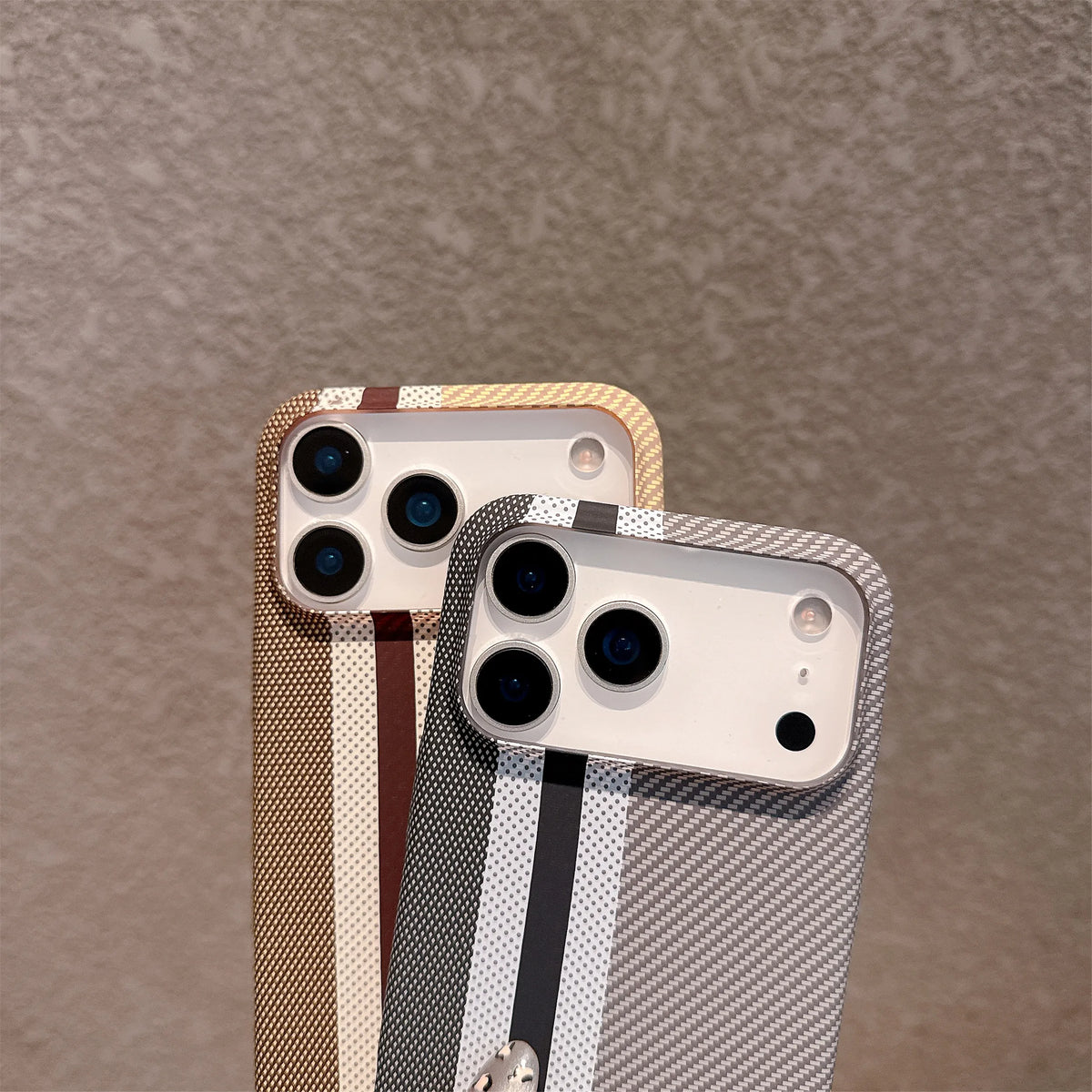Two phone cases with textured patterns on a brown background